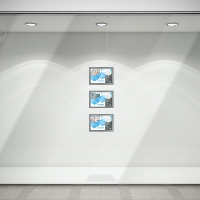 Montra de loja com três posters azuis e iluminação no teto