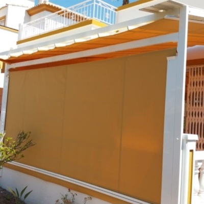 Toldo retrátil laranja numa varanda exterior