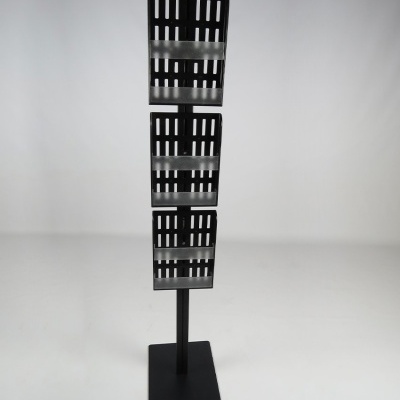 Expositor vertical preto com três suportes de metal perfurado em fundo branco