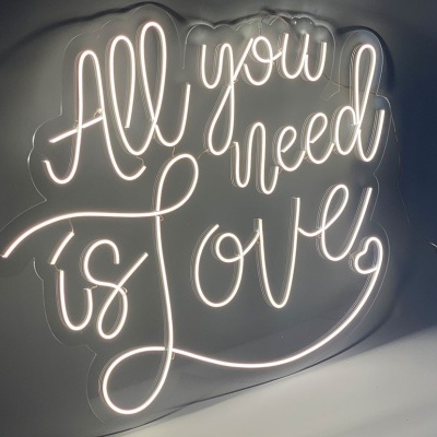 Luzes de néon brancas na parede com o texto 