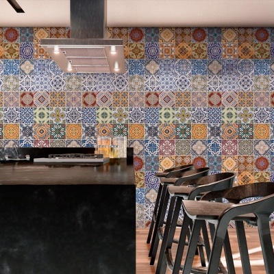 Cozinha moderna com bancada preta, azulejos coloridos e cadeiras altas pretas
