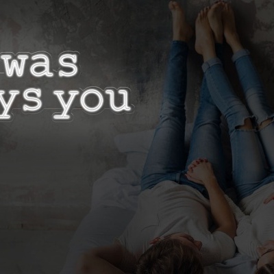 Duas pessoas deitadas numa cama contra uma parede cinzenta com texto branco