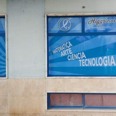 Fachada com janelas azuis e texto em branco de centro STEAM chamado Higgins