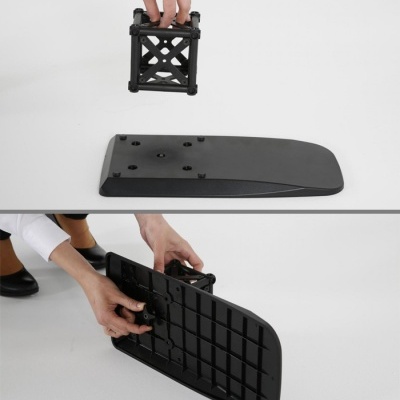 Peça preta de plástico com base para fixação sendo manuseada por uma pessoa