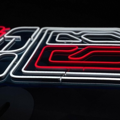 Letreiro em néon geométrico vermelho e branco numa parede escura