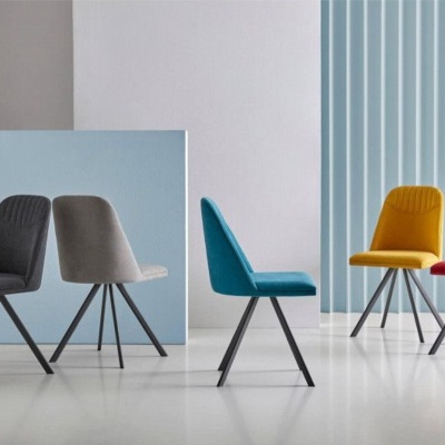 Conjunto de quatro cadeiras coloridas estofadas com pernas metálicas pretas