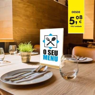Mesa posta com prato branco, talheres, copo e menu iluminado num ambiente de restaurante