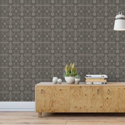 Móvel de madeira clara sob papel de parede cinza escuro com padrão floral, com vasos de plantas e livros em cima