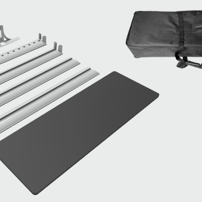 mesa portátil desmontada com peças metálicas e bolsa preta para transporte