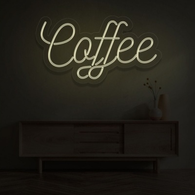 Sinal de néon branco com a palavra Coffee numa parede acima de uma consola de madeira escura com um vaso branco