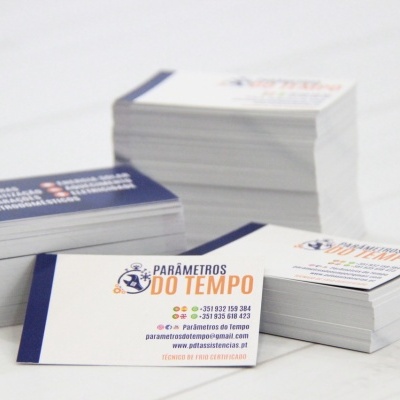 Cartões de visita empilhados em papel branco com texto azul e laranja