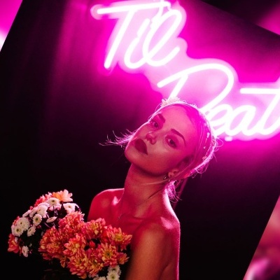 Mulher com flores em luz neon rosa