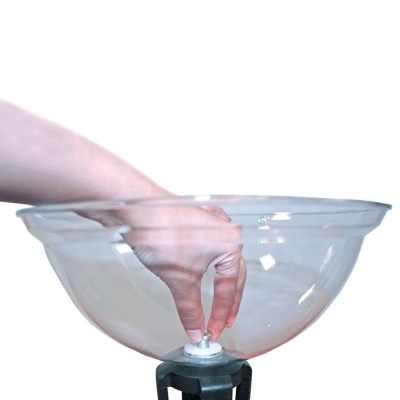 Taça transparente com base preta e mão a ajustar parafuso.