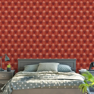 Quarto com parede vermelha almofadada e cama com colcha cinzenta