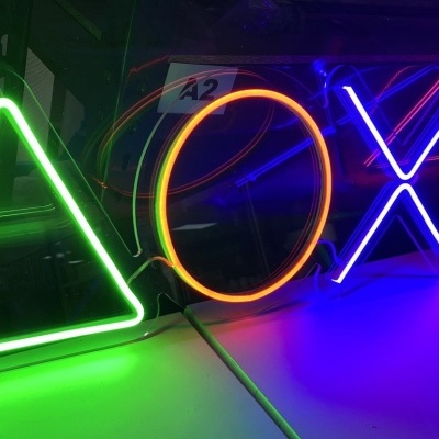 Sinais de neon coloridos em forma de triângulo verde, círculo laranja, X azul e quadrado vermelho alinhados