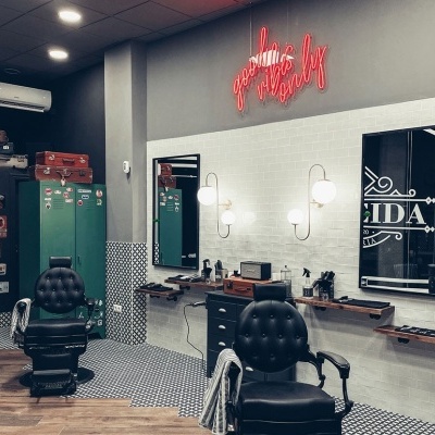 Salão de beleza com cadeiras de barbeiro pretas e decoração moderna.