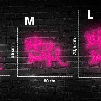 Neon rosa com texto 'life is beautiful' em três tamanhos contra parede de tijolos pretos