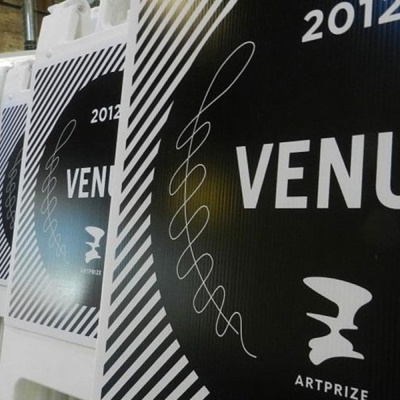 Placas plásticas brancas com cartazes pretos e texto branco VENUE ARTPRIZE 2012