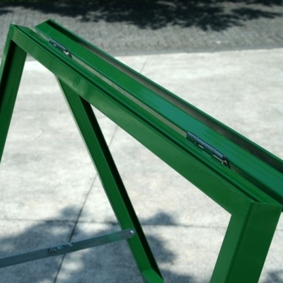 Estrutura metálica verde tipo cavalete sobre piso de betão