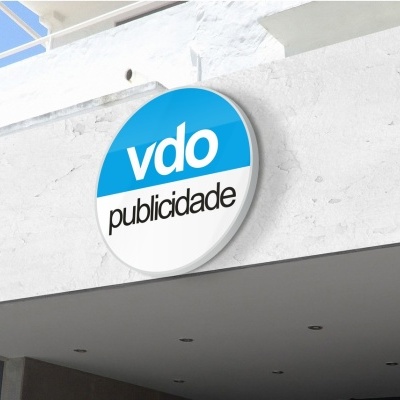 Placa redonda azul e branca com texto vdo publicidade na parede de um edifício