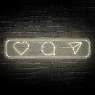 Néon branco com ícones de coração, balão de fala e avião de papel numa placa retangular contra parede de tijolos escuros
