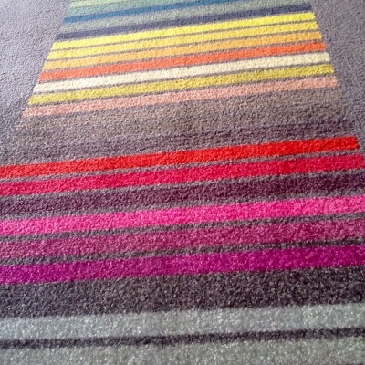 tapete colorido com riscas horizontais sobre chão