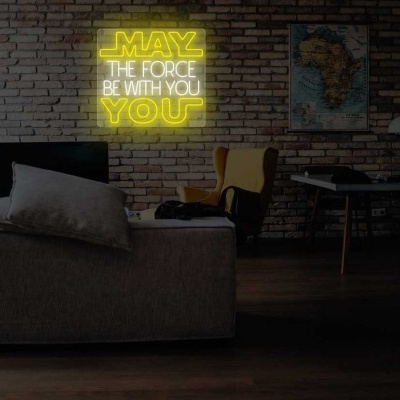 Sala de estar com sofá cinza, cadeira amarela, mesa de madeira e letreiro de néon amarelo na parede