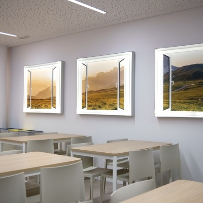 Sala com mesas, cadeiras e quadros iluminados na parede com paisagens campestres