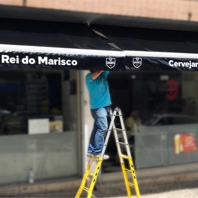 Toldo preto com texto branco 'Rei do Marisco' e 'Cervejaria Rei do Marisco' na fachada