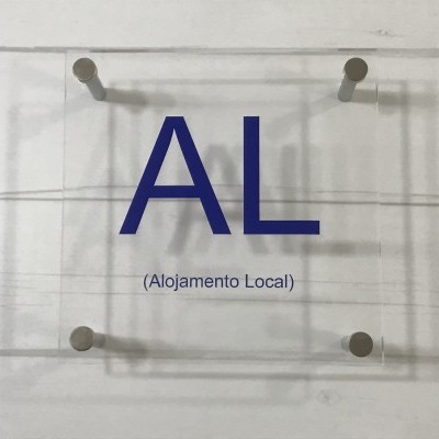 Placa acrílica com texto AL e Alojamento Local na parede