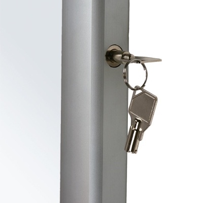 Fechadura com chave numa porta cinza claro