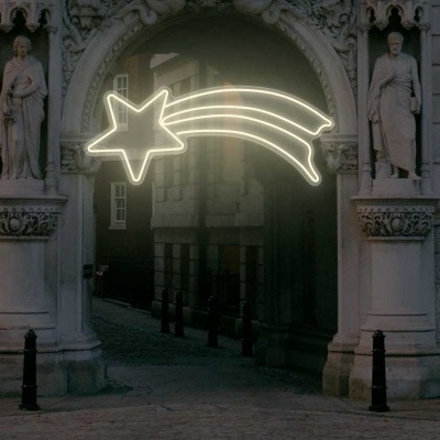 Iluminação decorativa de estrela cadente branca num arco de pedra