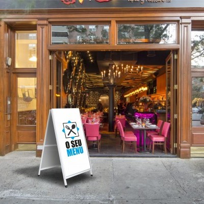 Expositor de menu branco com texto 'O SEU MENU' à entrada de restaurante com cadeiras rosa