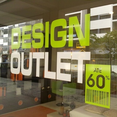 Montra de loja com texto DESIGN OUTLET e cartaz de desconto ATE 60%