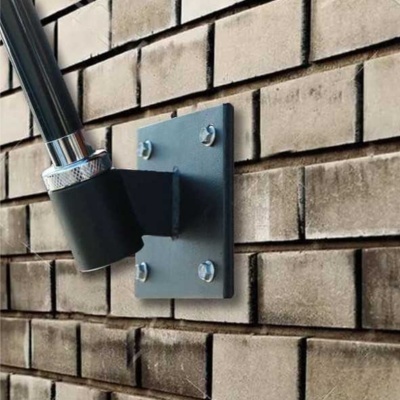 Suporte de metal preto fixado em parede de tijolos com objeto cilíndrico preto