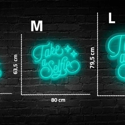 Placas luminosas em néon azul com texto 'Take a Selfie' em diferentes tamanhos contra parede preta