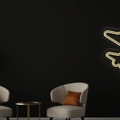 Decoração interior com neon de avião, cadeiras cinza e planta em vaso branco