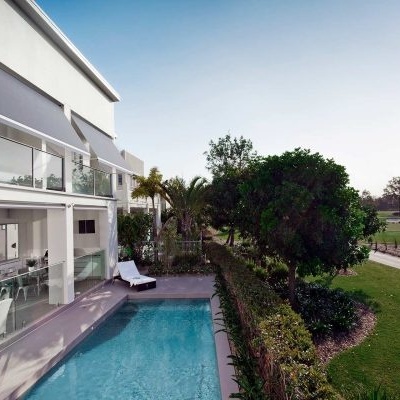 Piscina exterior azul em residência moderna com área verde