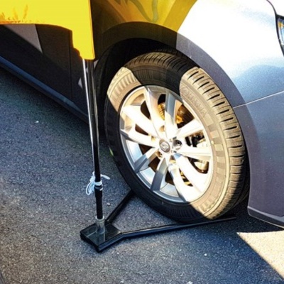 Roda dianteira direita de automóvel prateado com macaco hidráulico preto