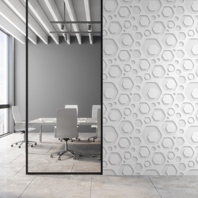 Parede 3D branca hexagonal num escritório moderno com cadeiras e mesas brancas e chão cinzento