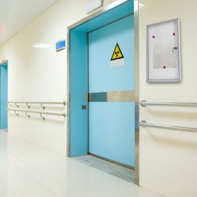 Porta azul clara com sinal de radiação nuclear no corredor hospitalar