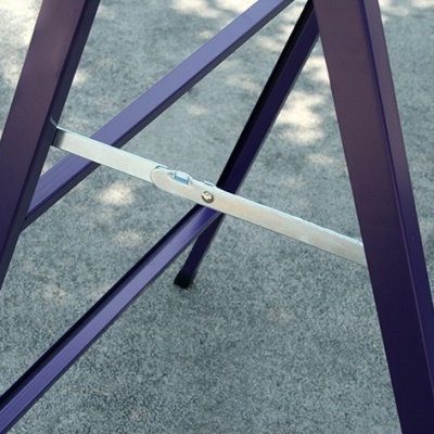 Estrutura metálica roxa com barra metálica prateada sobre piso cinzento