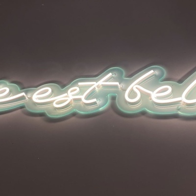 Neon com a frase 'la vie est belle' em letras cursivas iluminadas