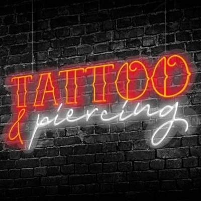 Letreiro de néon com as palavras TATTOO & piercing em vermelho e branco numa parede de tijolos