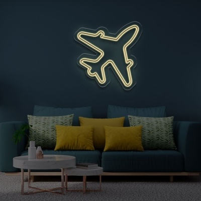 Sala de estar com sofá azul com almofadas amarelas e cinzentas, luz de néon em forma de avião na parede azul