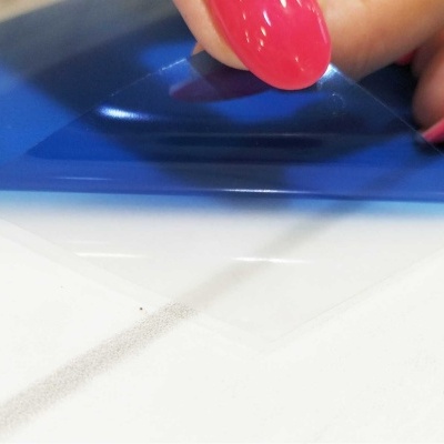 Mão com unhas vermelhas a segurar embalagem plástica azul