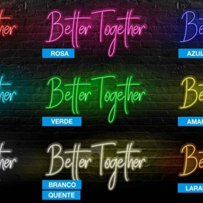 Sinais luminosos em néon com texto 'Better Together' em várias cores contra parede de tijolos