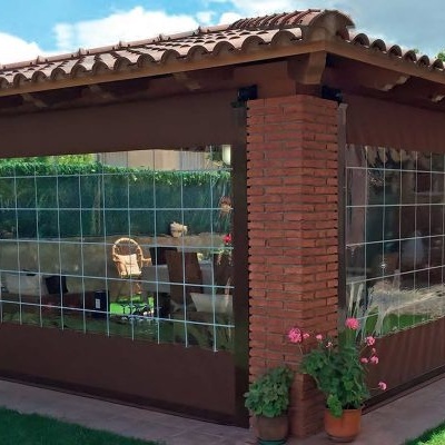 Estrutura exterior de madeira com tijolo e cortinas transparentes