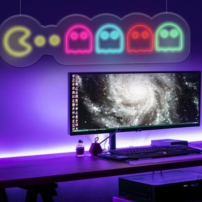 Estação de trabalho com monitor ultrawide e luz LED temática de Pac-Man colorida.
