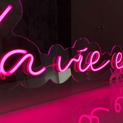 Letreiro em néon cor de rosa com frase La vie est belle